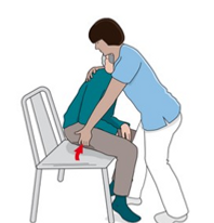 En person som sitter på en stol med ett rött föremål i handen.