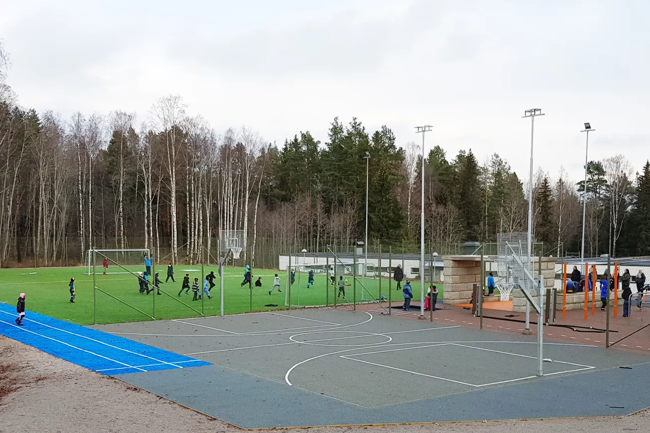 Arena med en massa ytor för sport, många barn leker på ytorna.