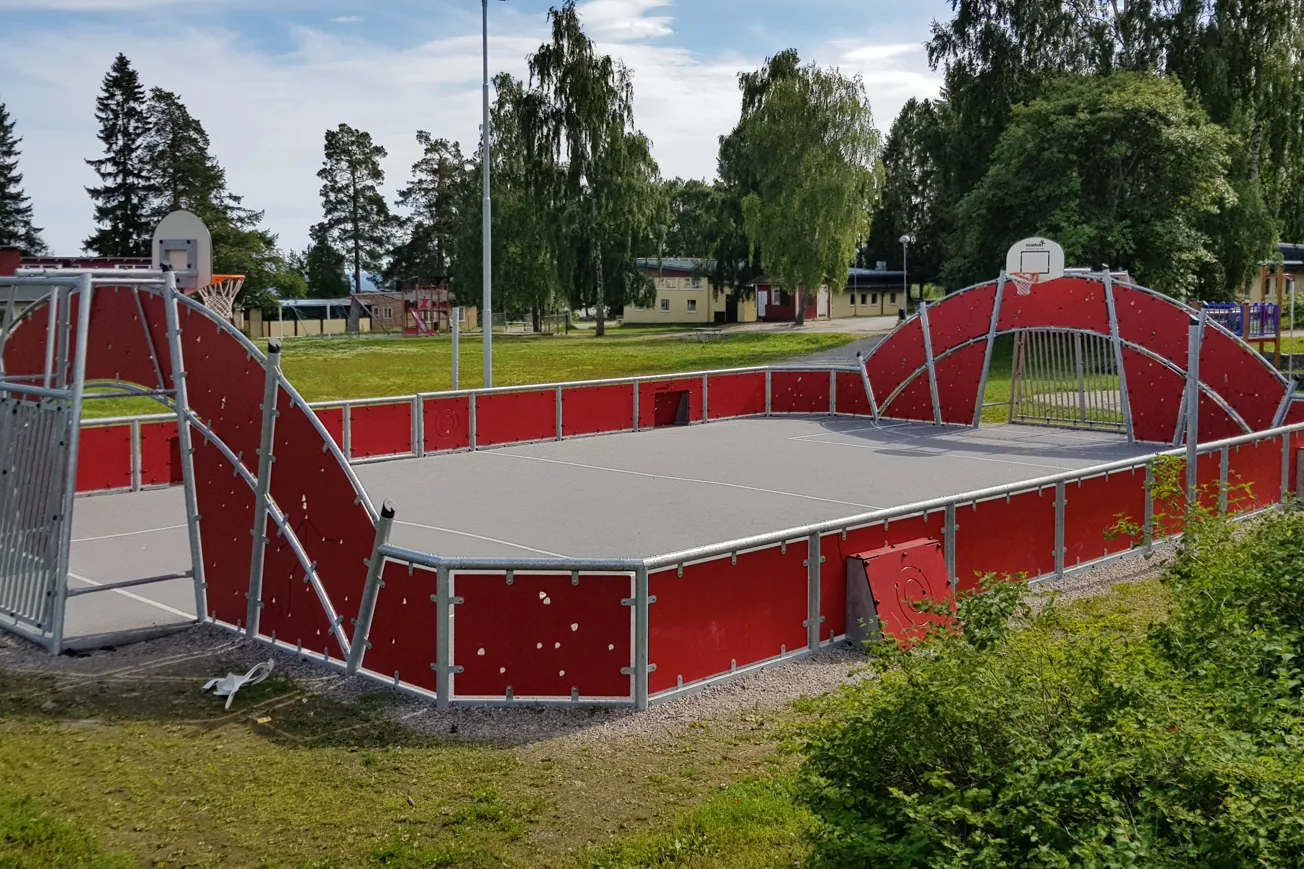 Arena på skolgård, konstgräsplan med sarg runt om.