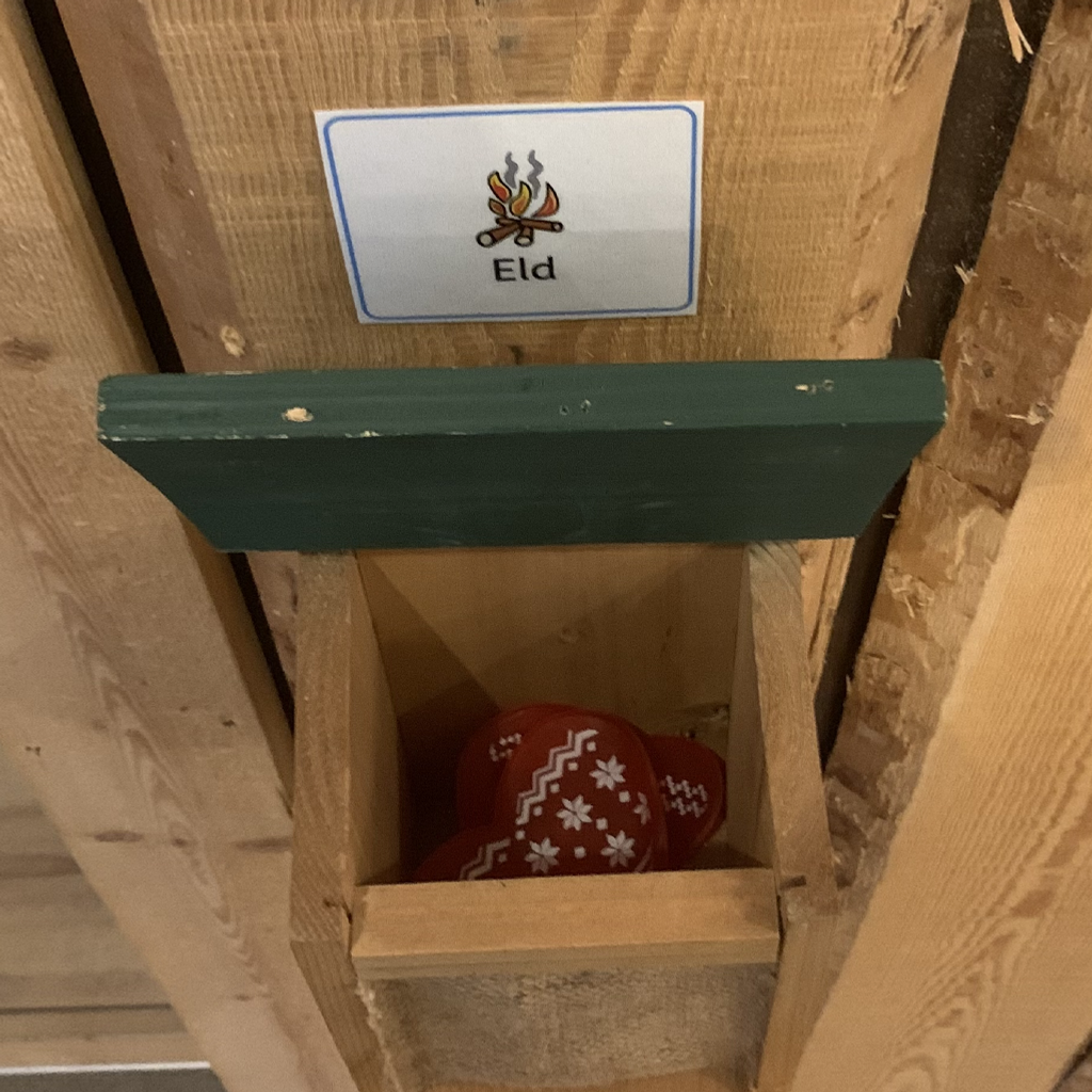 En röd och vit boll i en trälåda.