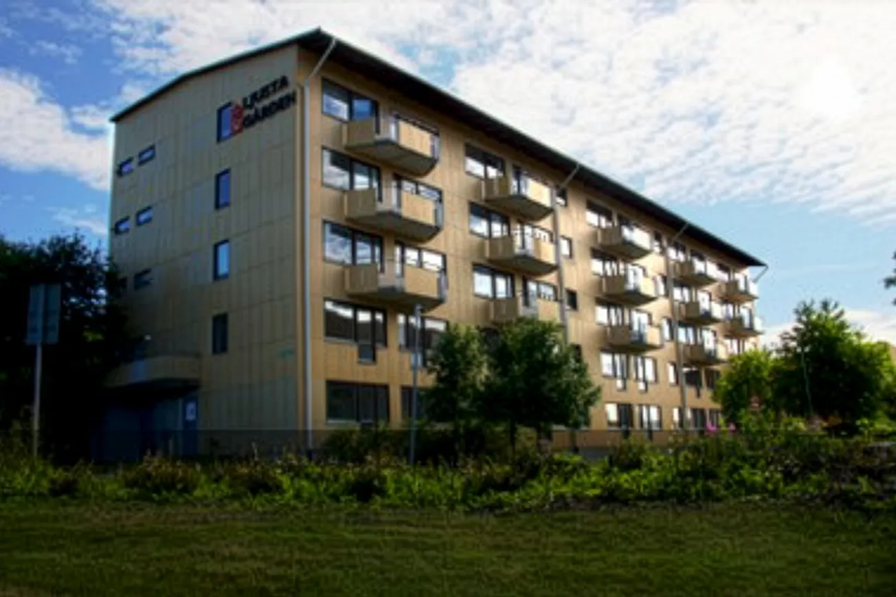 En hög byggnad som ligger på ett grönskande fält.