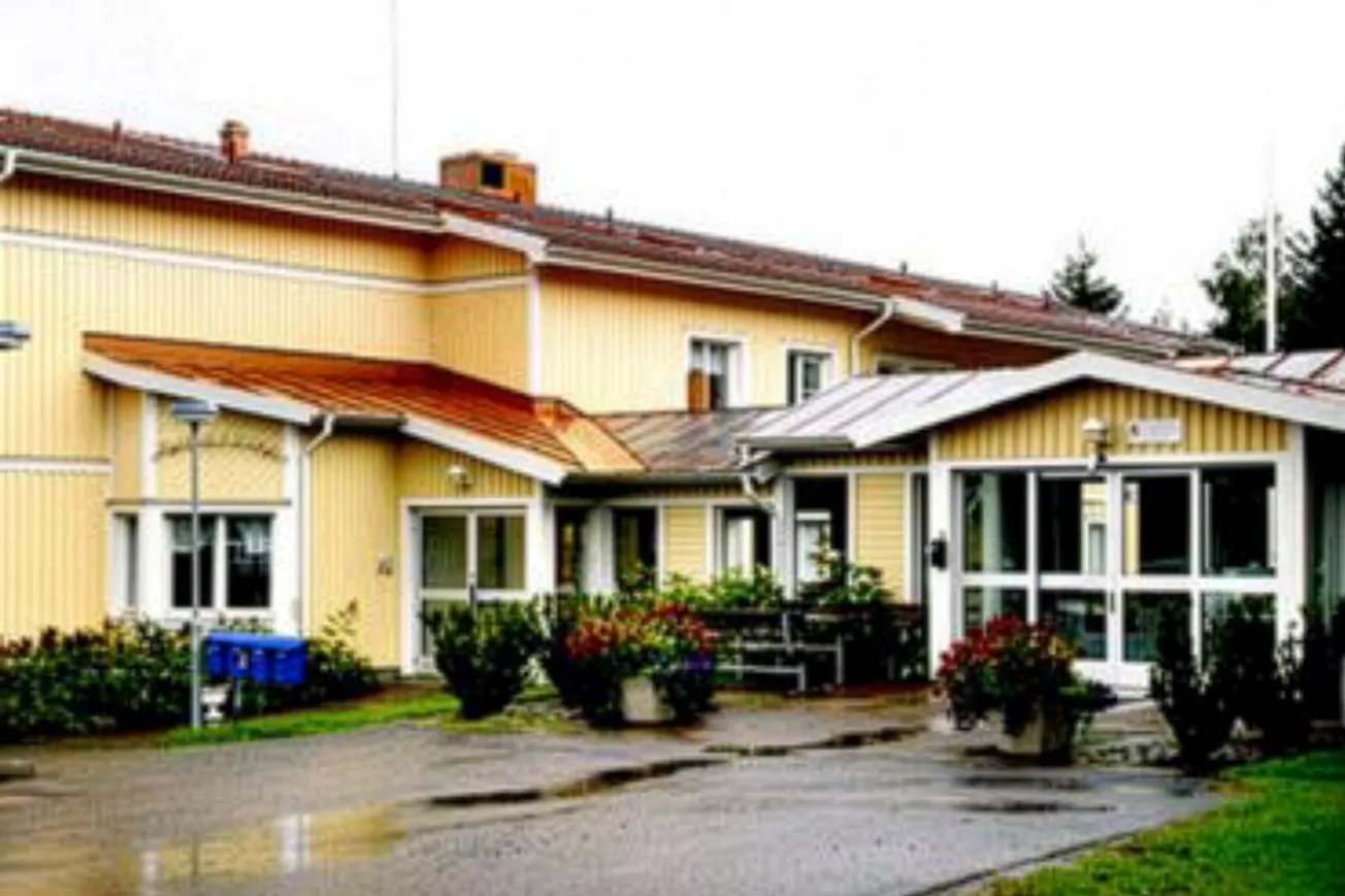En gul byggnad med rött tak på en regnig dag.