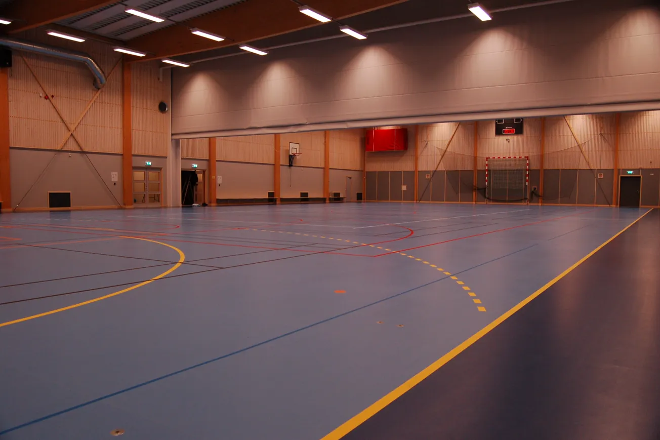 Idrottshall med många linjer på golvet för olika idrotter.