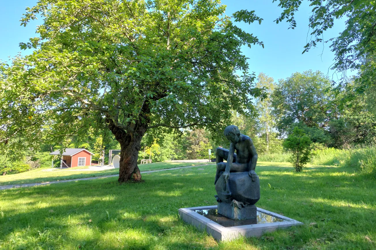 En skulptur i lummig parkmiljö.